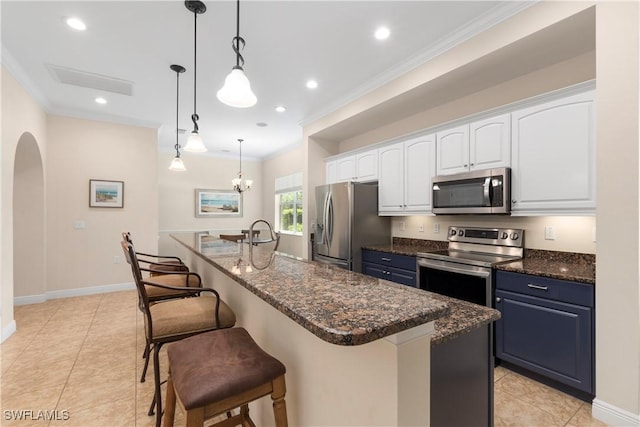 10696 Camarelle Cir, Fort Myers, FL 33913 - kitchen featuring stainless steel appliances, white cabinets, ornamental molding, a breakfast bar area, and arched walkways