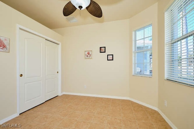 unfurnished bedroom featuring light tile patterned floors, a closet, and ceiling fan