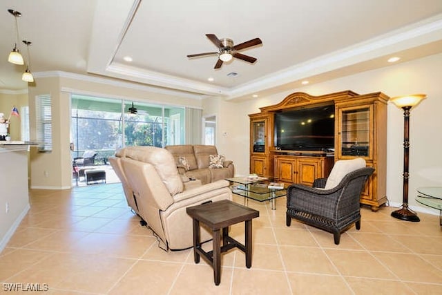 living room with light tile patterned flooring, ceiling fan, ornamental molding, and a tray ceiling