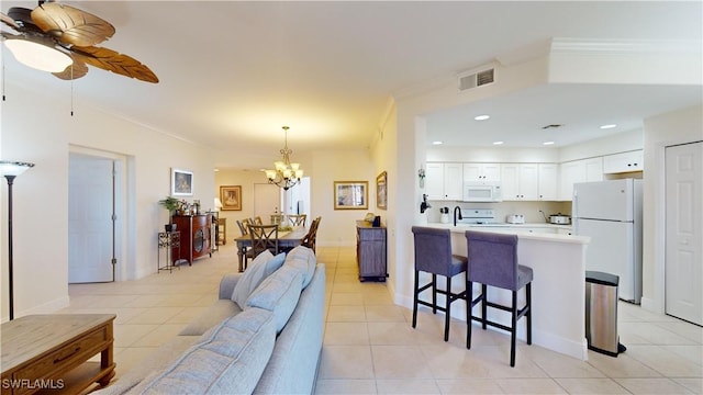 kitchen featuring white cabinetry, light tile patterned floors, white appliances, and ornamental molding