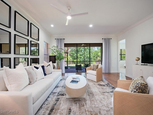 living room with hardwood / wood-style flooring, ornamental molding, and ceiling fan