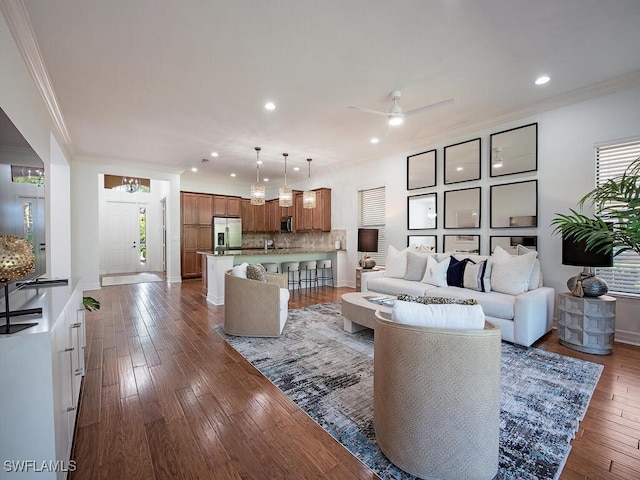 living room featuring ornamental molding, wood-type flooring, and ceiling fan