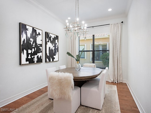 dining room featuring ornamental molding, hardwood / wood-style floors, and an inviting chandelier