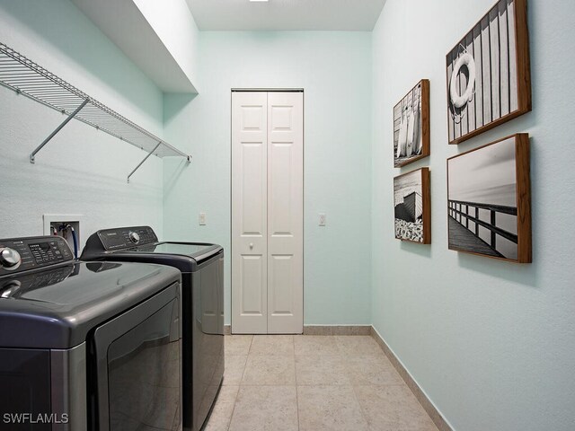 laundry area featuring light tile patterned flooring and washing machine and dryer