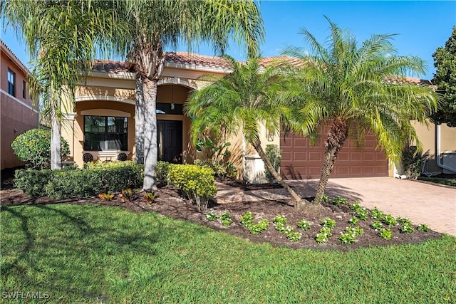 mediterranean / spanish-style home featuring a garage and a front yard