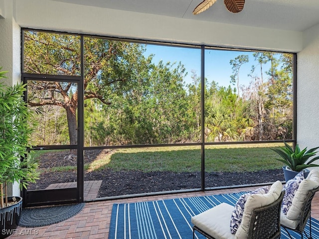 unfurnished sunroom featuring ceiling fan