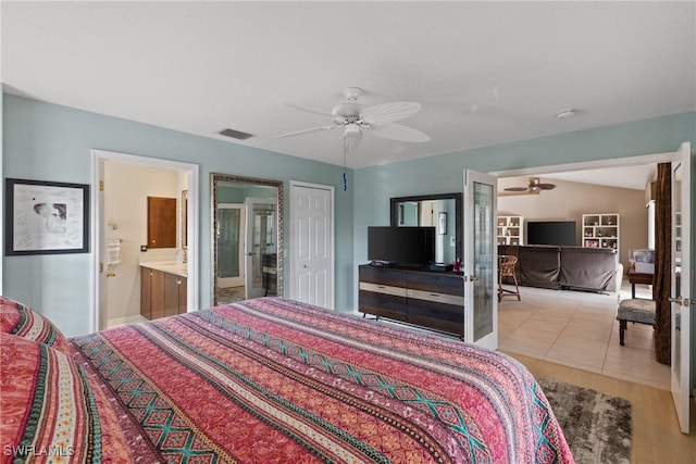 bedroom with light tile patterned floors, visible vents, connected bathroom, ceiling fan, and french doors