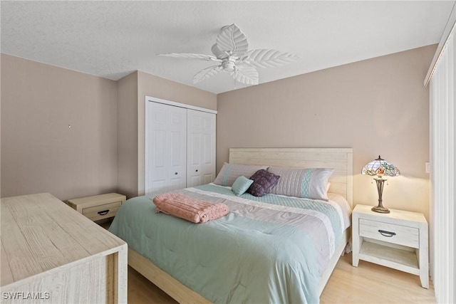 bedroom with a closet, wood finished floors, and a ceiling fan