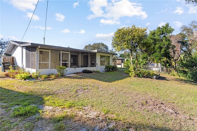 rear view of property with a sunroom and a yard