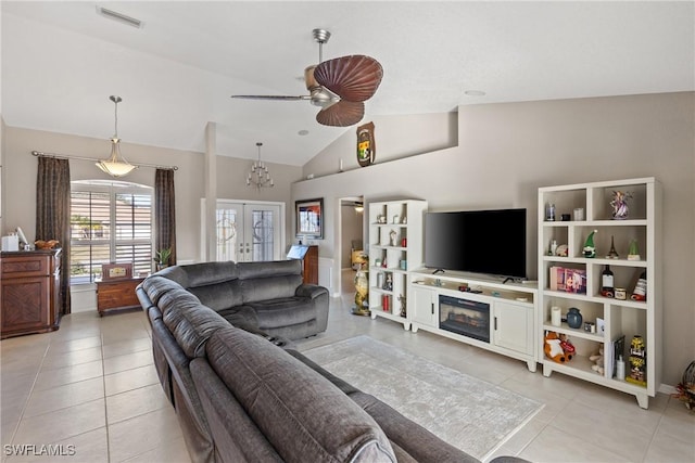 living area featuring french doors, visible vents, vaulted ceiling, and light tile patterned floors