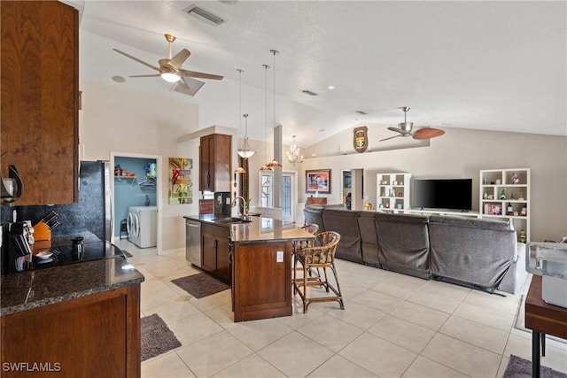 kitchen featuring visible vents, open floor plan, appliances with stainless steel finishes, washing machine and clothes dryer, and pendant lighting