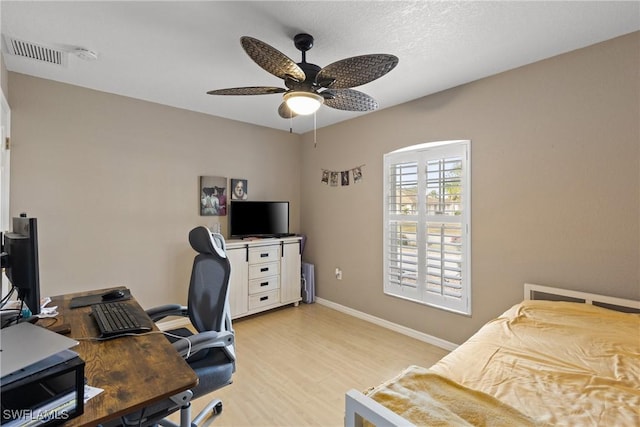 office area featuring baseboards, light wood-style floors, visible vents, and a ceiling fan