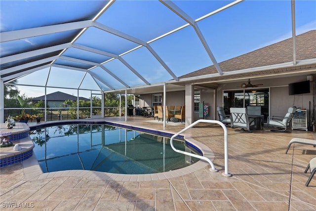 outdoor pool featuring glass enclosure and a patio area