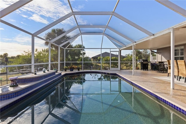 outdoor pool with a patio area, glass enclosure, and area for grilling