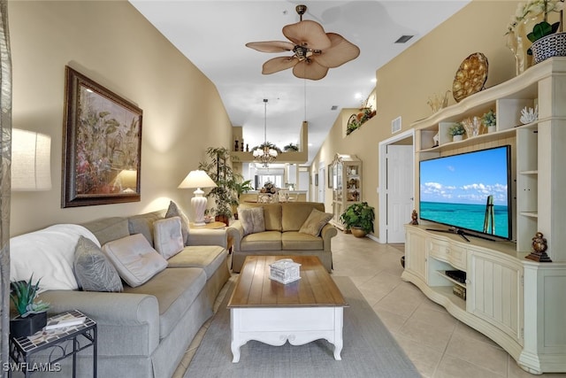 tiled living room with ceiling fan with notable chandelier and high vaulted ceiling