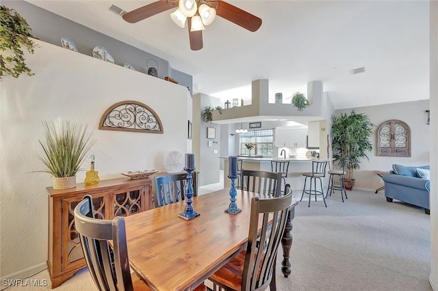 dining area with light carpet and ceiling fan