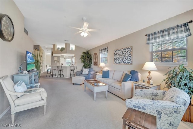 carpeted living room with ceiling fan, lofted ceiling, and a wealth of natural light