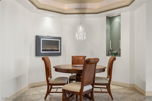 dining space featuring ornamental molding and a tray ceiling