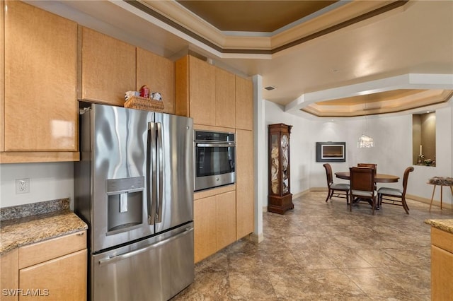 kitchen featuring light brown cabinetry, crown molding, stainless steel appliances, and a raised ceiling