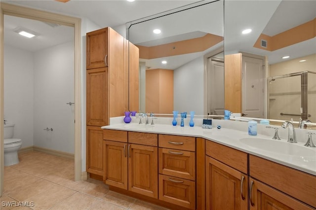 bathroom with vanity, tile patterned flooring, toilet, and walk in shower