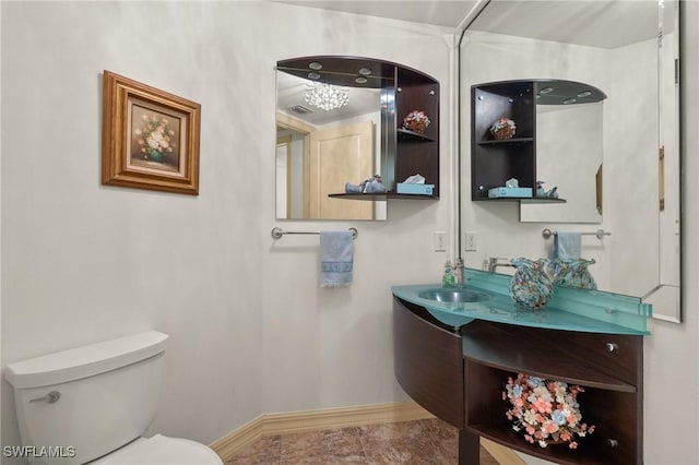 half bathroom with vanity, toilet, and baseboards