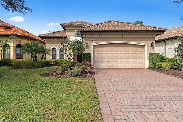 mediterranean / spanish home featuring a garage and a front yard