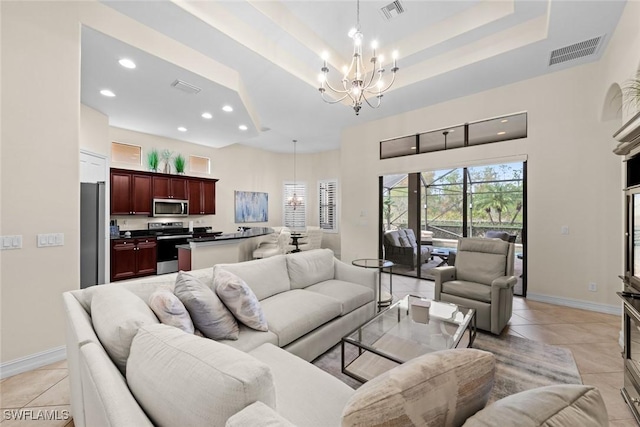 tiled living room with an inviting chandelier and a raised ceiling