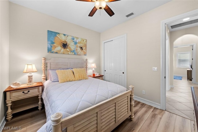 bedroom with light hardwood / wood-style floors, ceiling fan, and a closet