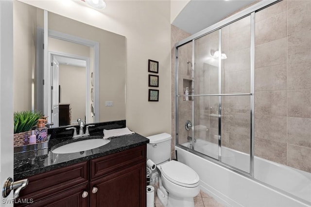 full bathroom featuring enclosed tub / shower combo, vanity, tile patterned floors, and toilet