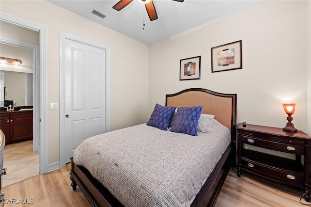 bedroom featuring ensuite bath, light hardwood / wood-style floors, a closet, and ceiling fan