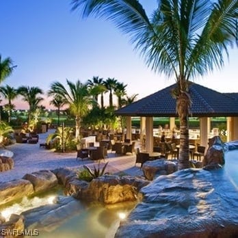 pool at dusk featuring a gazebo