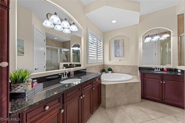 bathroom with tile patterned flooring, vanity, and shower with separate bathtub