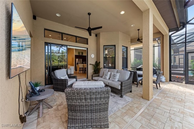 view of patio / terrace with outdoor lounge area, ceiling fan, and glass enclosure