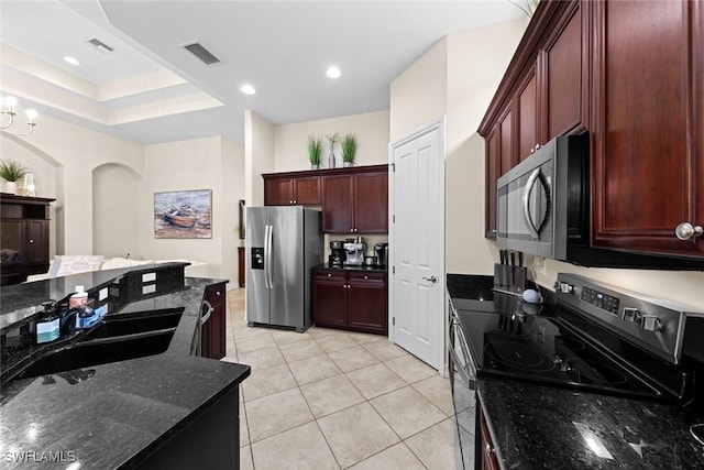 kitchen with appliances with stainless steel finishes, sink, light tile patterned floors, and dark stone counters