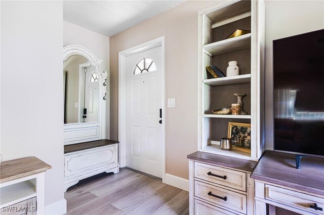 mudroom with built in features and light hardwood / wood-style floors