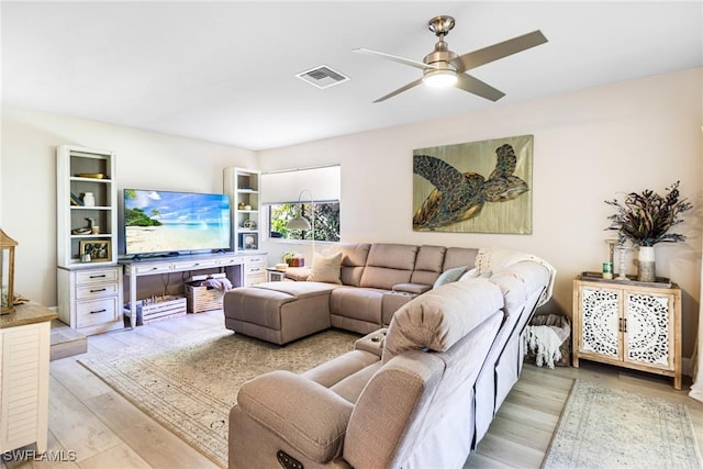 living room with light hardwood / wood-style flooring and ceiling fan