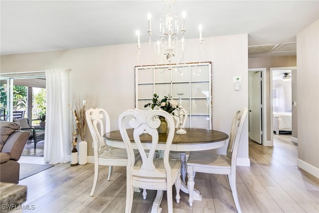 dining space with an inviting chandelier, baseboards, and light wood-style floors