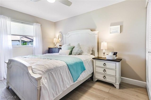 bedroom with light wood-style floors, baseboards, and ceiling fan