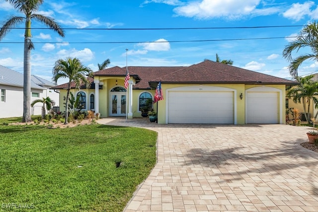 mediterranean / spanish-style home with stucco siding, french doors, decorative driveway, and a garage