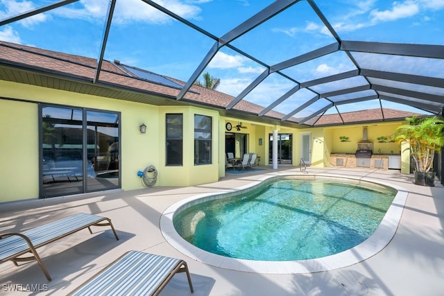 view of pool with a patio, an outdoor kitchen, and a lanai