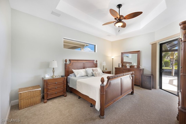 bedroom featuring access to exterior, light colored carpet, ceiling fan, and a raised ceiling