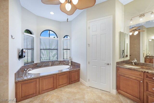 bathroom featuring ceiling fan, vanity, and a bath