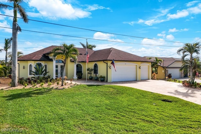 mediterranean / spanish home with stucco siding, driveway, a garage, and a front yard