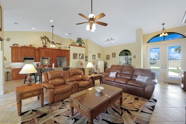 tiled living room featuring ceiling fan, high vaulted ceiling, and french doors