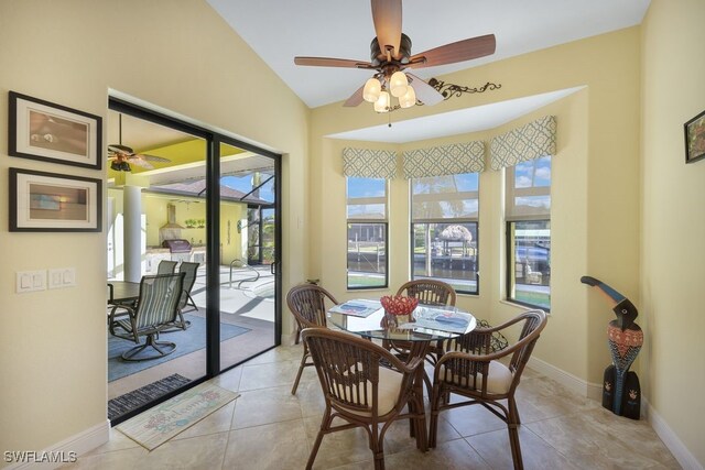 tiled dining room featuring vaulted ceiling and ceiling fan