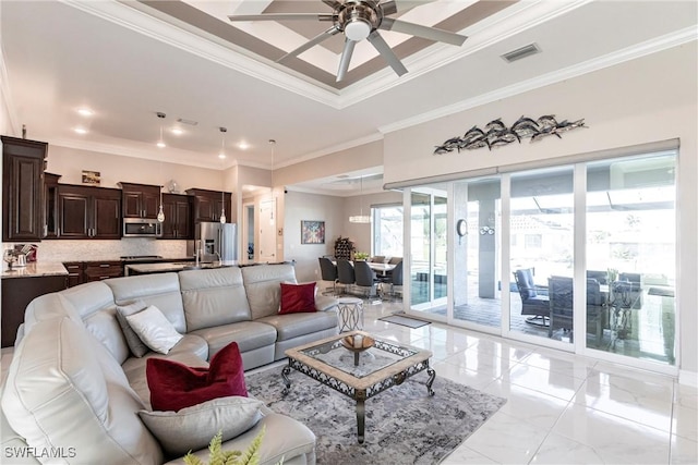 living room with crown molding, ceiling fan, and a tray ceiling