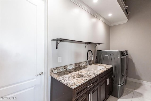 clothes washing area featuring cabinets, ornamental molding, and sink