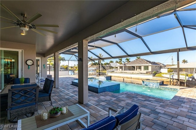 view of pool with a jacuzzi, a patio, pool water feature, and glass enclosure