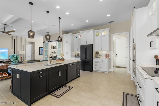 kitchen featuring dark cabinets, white cabinetry, black appliances, and a barn door