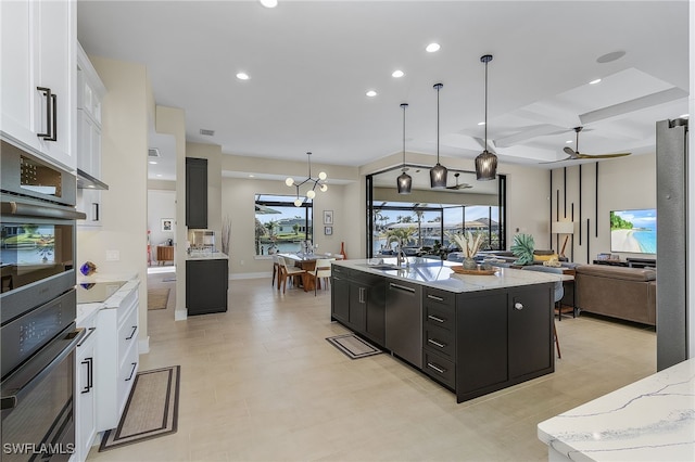 kitchen with a center island with sink, recessed lighting, open floor plan, white cabinets, and dark cabinets